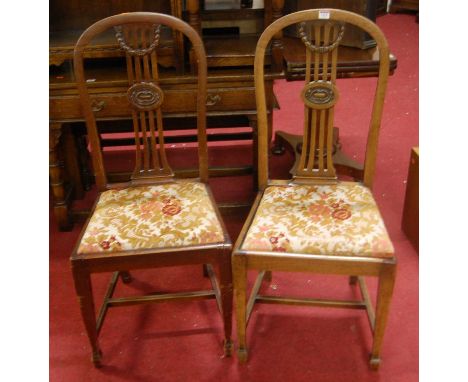 A set of four early 20th century mahogany slat back dining chairs, each having floral tapestry inset drop-in seats