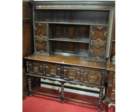 An early 20th century geometric moulded oak dresser, the panelled upper section with oak twin open plate rack with twin cupbo