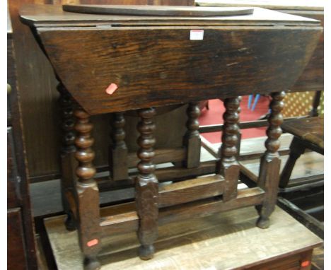 An antique provincial joined oak bobbin turned gateleg drop leaf occasional table (with damage to one leaf)