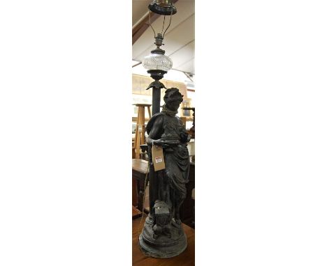 A large early 20th century spelter table lamp, modelled as a standing Greek goddess dressed in robes, leaning on a compositio