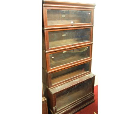 An early 20th century mahogany Globe Wernicke five-tier stacking bookcase, having typical hinged glazed doors, raised on a sh