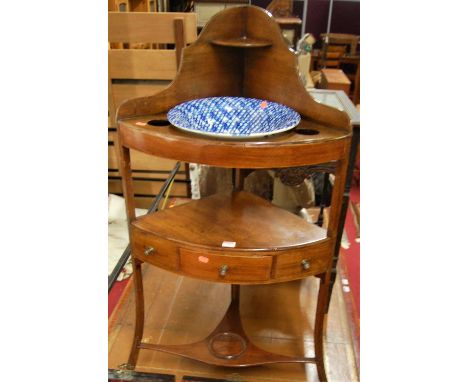 An early 19th century mahogany bowfront three-tier corner washstand, with later ceramic bowl