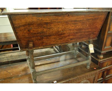 An antique joined oak dough bin, having a fall front panel raised on ring turned supports, united by stretchers, width 119cm