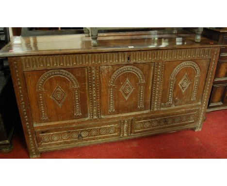 An 18th century joined and chip carved oak three panelled hinge top mule chest, having twin short lower drawers, width 146cmC
