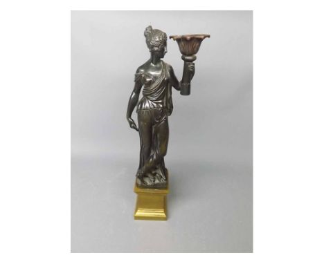 Bronzed table lamp formed as a figure holding a torch raised on a polished brass base  