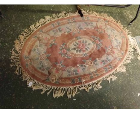 Chinese pink ground and floral bordered oval thick pile wool carpet, with tasselled edge, 60  x 36  