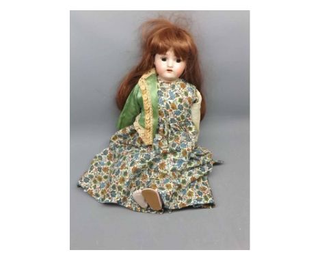 Large shoulder and head doll with bisque head, glass eyes and painted decoration to face, with long hair and a dress with gre