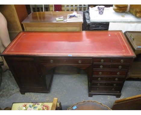 An early 19th century mahogany twin pedestal desk with a central drawer flanked by six drawers and a door, on bracket feet 31