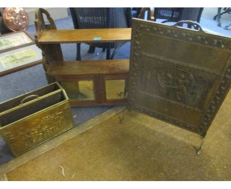 An early 20th century mahogany wall shelf with cupboard below, a brass fire guard and brass magazine rack 