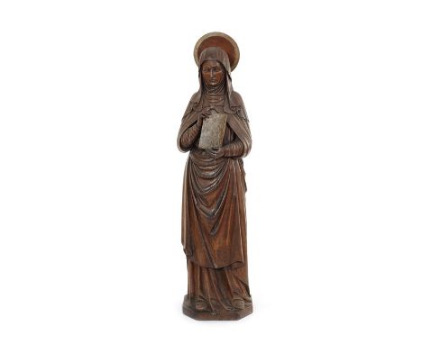 A large 19th century carved oak standing figure of a female saintHolding a book and with a halo, 101cm high.