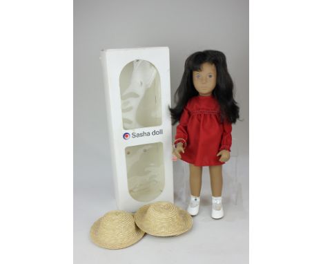 A Sasha doll, with brown hair and brown eyes, no.104, in red dress, white socks and shoes, with makers tag to wrist, 42cm hig