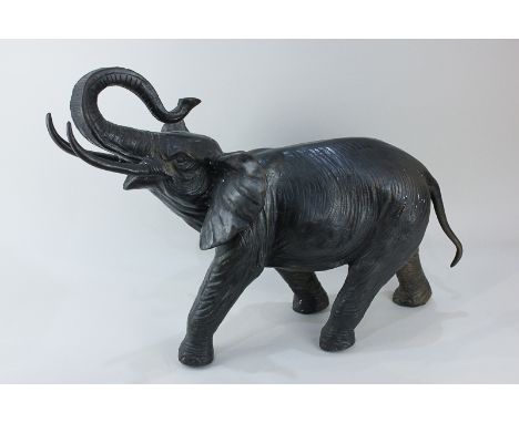A bronzed metal sculpture of an elephant with raised trunk, 40cm high