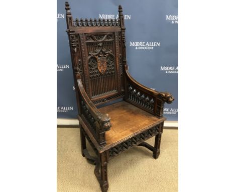 A Victorian Gothic Revival carved oak throne chair in the manner of Pugin, the pierced carved top rail flanked by French baro