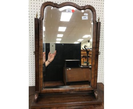A walnut framed dressing mirror in the early 18th Century manner, the Vauxhall style bevel edged plate within a moulded frame