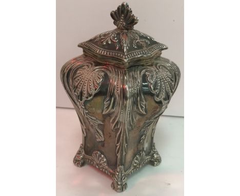 An Edwardian silver tea caddy of bombé form with embossed acanthus and shell decoration raised on four scrolling feet (by Tho