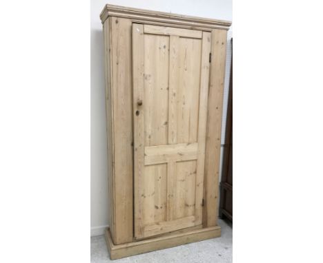 A Victorian pine single door cupboard of slim proportions, the four panelled door enclosing four shelves on a plinth base 110