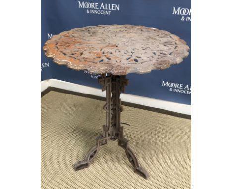 A pierced cast iron tripod table in the Victorian aesthetic taste, the circular top with foliate decoration on a flower head 