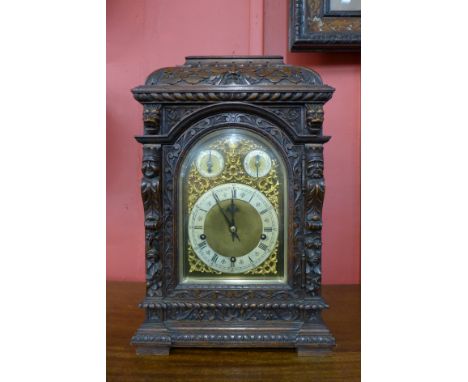 A 19th Century German Winterhalder &amp; Hofmeier carved oak bracket clock, with brass arched dial, the movement having four 