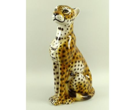 An Italian ceramic model of a seated cheetah, base incised Italy, possibly by Intrada, 24 by 48cm high.