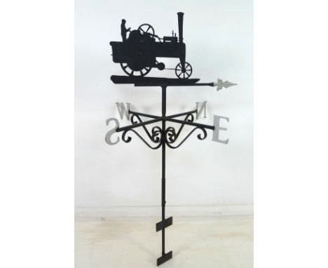 A modern weather vane, modelled as a man driving a vintage steam engine, painted black with silvered arrow pointer, 57 by 43c