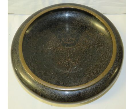 A black cloisonne bowl depicting dragon and pearl amongst clouds, all black enamel except for the large four character mark t