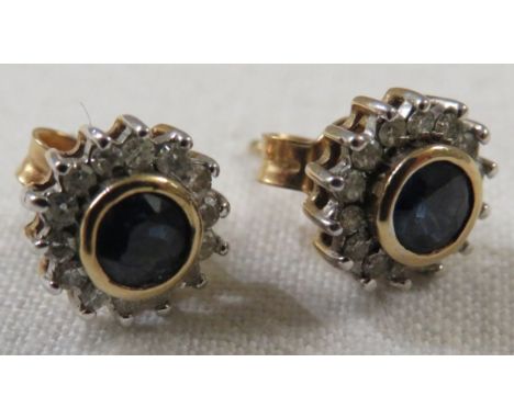 Pair of 9-carat gold earrings each set with a round cut sapphire (about 4mm diameter) within a halo of fourteen very small di