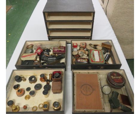 An assortment of optical components including gun sight parts contained in a vintage Advance 'The Leader' four-drawer filing 