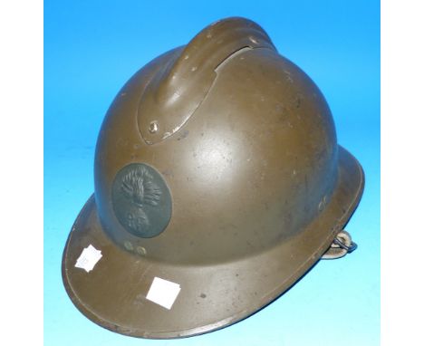 A WWII style French helmet with relief badge