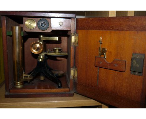 A 19th century brass microscope with eye pieces and slides, in fitted mahogany case