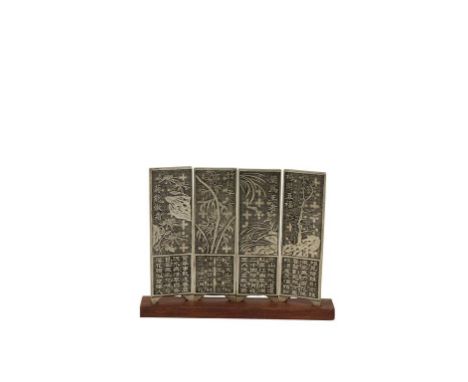 A CHINESE SILVER MINIATURE FOUR-FOLD SCREEN cast with lotus, pine and bamboo below calligraphic panels, on a wood base, 16cm 
