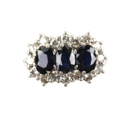 1970's sapphire and diamond dress ring, set with three oval cut sapphires, estimated total sapphire weight 2.40 carats, surro