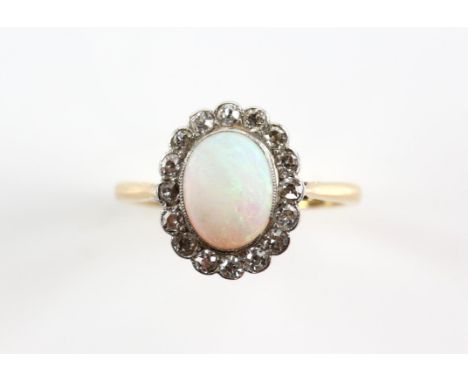 Edwardian opal and diamond cluster ring, central oval cabochon cut opal, estimated weight 1.34 carats, surrounded by a frame 