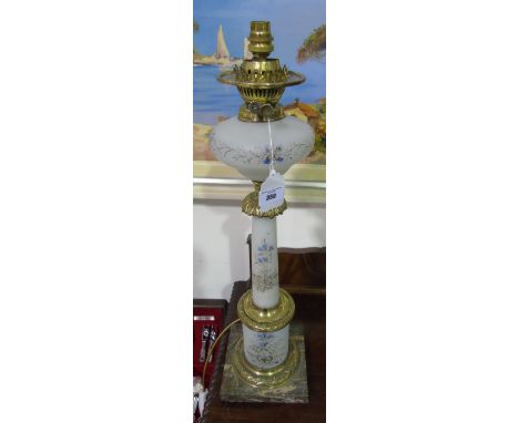 An Electrified Oil Lamp with painted opaque glass column & reservoir, on a marble base