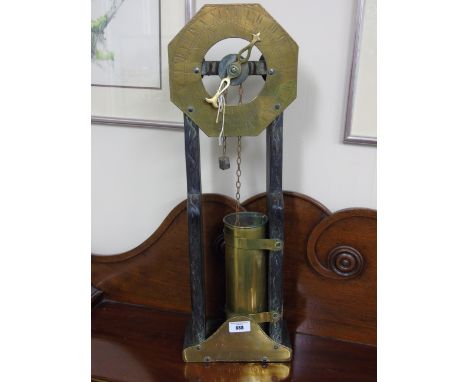 A 19th Century Water Clock, with carved wooden frame, engraved brass dial with Roman numerals, plate to base with engraved sc