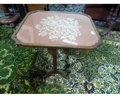 An Early 20th Century Folding Walnut Fire Screen/Occasional Table.Having a glazed textile panel.