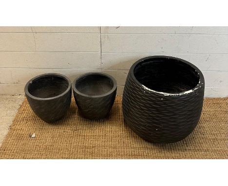 A black wave style planter and two grey textured planters 