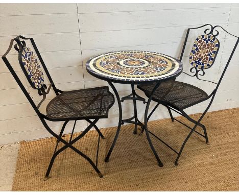 A black metal bistro set with mosaic tile top and seat backs 