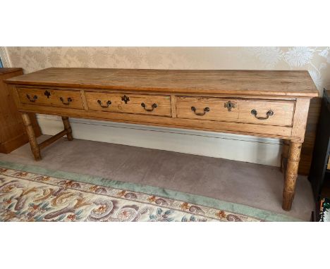 A pine console table with three long drawers (H79cm W227cm D53cm)