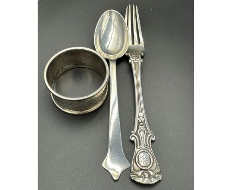 A hallmarked silver fork, spoon and napkin ring with a combined approximate weight of 89g.