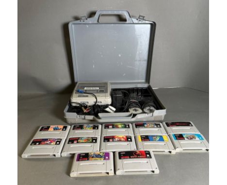 A Super Nintendo games console with a collection of game cartridge to include Super Mario Kart and Mortal Kombat 