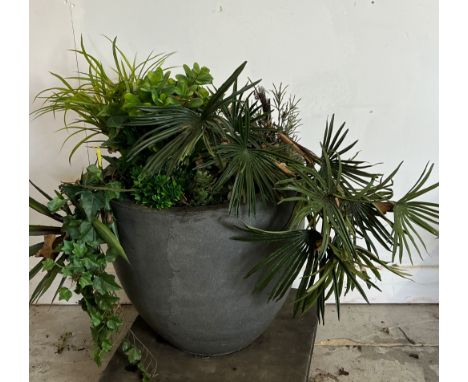 A large copper style planter with artificial palms and ivy 