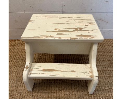 A white painted step footstool with a hinged lid opening to storage 
