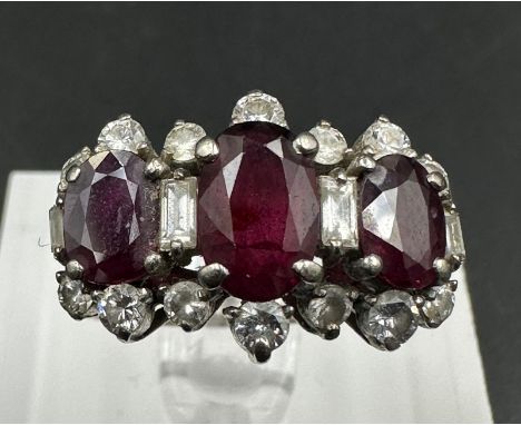 A Ruby and Diamond ring on 18ct white gold, approximate size Q. Center stone is 1.10ct and side stones are 0.6ct each.