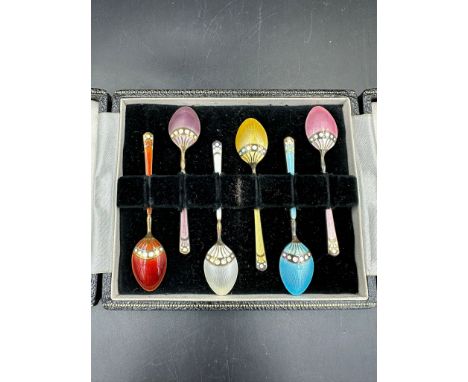 A boxed set of enamel on silver teaspoons, cased. Hallmarked for Birmingham.