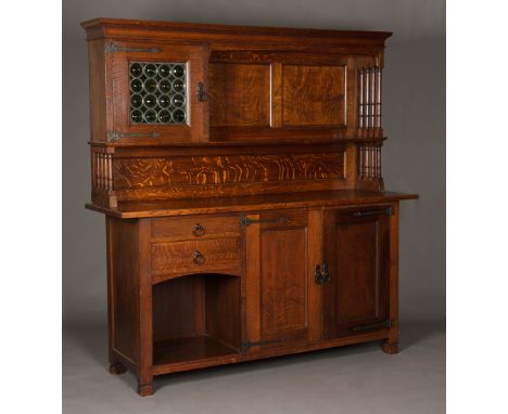 An Edwardian Arts and Crafts oak 'Lochleven' sideboard by Liberty & Co, the shelf back with a leaded glazed cabinet with turn