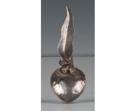 An Arts and Crafts silver caddy spoon by Margaret Creed, the hammered bowl with a eucalyptus leaf and berry handle, the bowl 