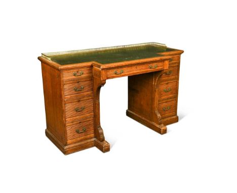 An Aesthetic period oak pedestal desk by Gillow & Co., of breakfront outline, the leather inset top with brass gallery back, 