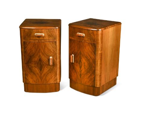 A pair of Art Deco walnut bow front bedside cupboards, each with single frieze drawer and cupboard below raised on a plinth b