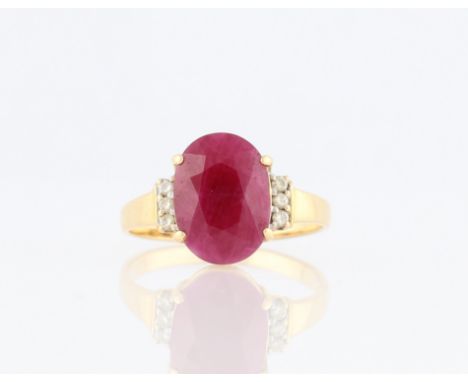 A ruby and diamond ring, set with a central oval cut ruby (possibly treated), measuring approx. 12x9mm, flanked to either sid
