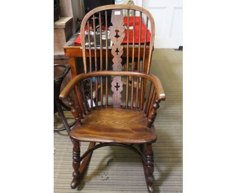 A 19th century slat &amp; stick back rocking armchair, with solid elm seat